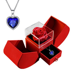 Red box with a heart-shaped blue gem necklace and a red rose inside